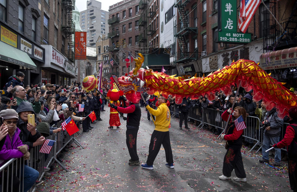 Participants march with a dragon caricature during the Lunar New Year parade in Manhattan's Chinatown neighborhood, in New York, Sunday, Feb. 9, 2020. (AP Photo/Craig Ruttle)
