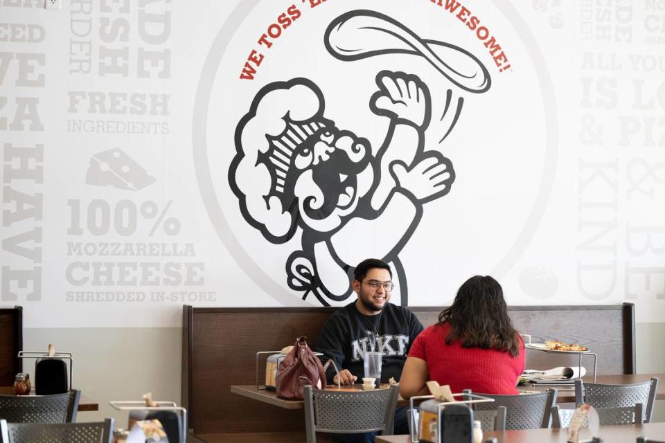 Claudio DeSousa and Luisa Elisaia eat lunch at Pizza Factory in Turlock, Calif., Tuesday, Oct. 17, 2023.