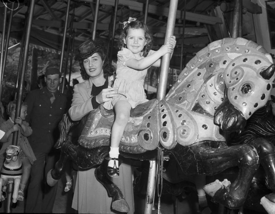 April 7, 1945: The Forest Park Zoo and amusement park opened their spring season to a large crowd. Jeanette Gibson, 3, enjoyed her day at the zoo. She is the daughter of Flight Officer and Mrs. J.L. Gibson. She is laughing as she rides “Prancing Beauty” on the merry-go-round. Flight Officer Gibson is station at Langley, Virginia.