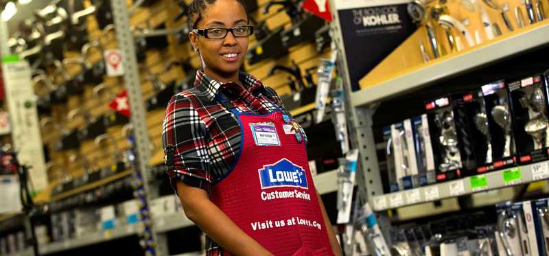 A Lowe's employee stands in an aisle.