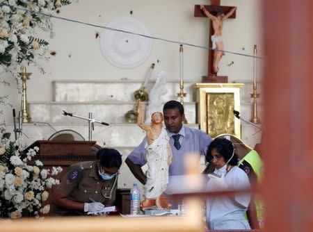 Police officers work at the scene at St. Sebastian Catholic Church, after bomb blasts ripped through churches and luxury hotels on Easter, in Negombo, Sri Lanka April 22, 2019. REUTERS/Athit Perawongmetha