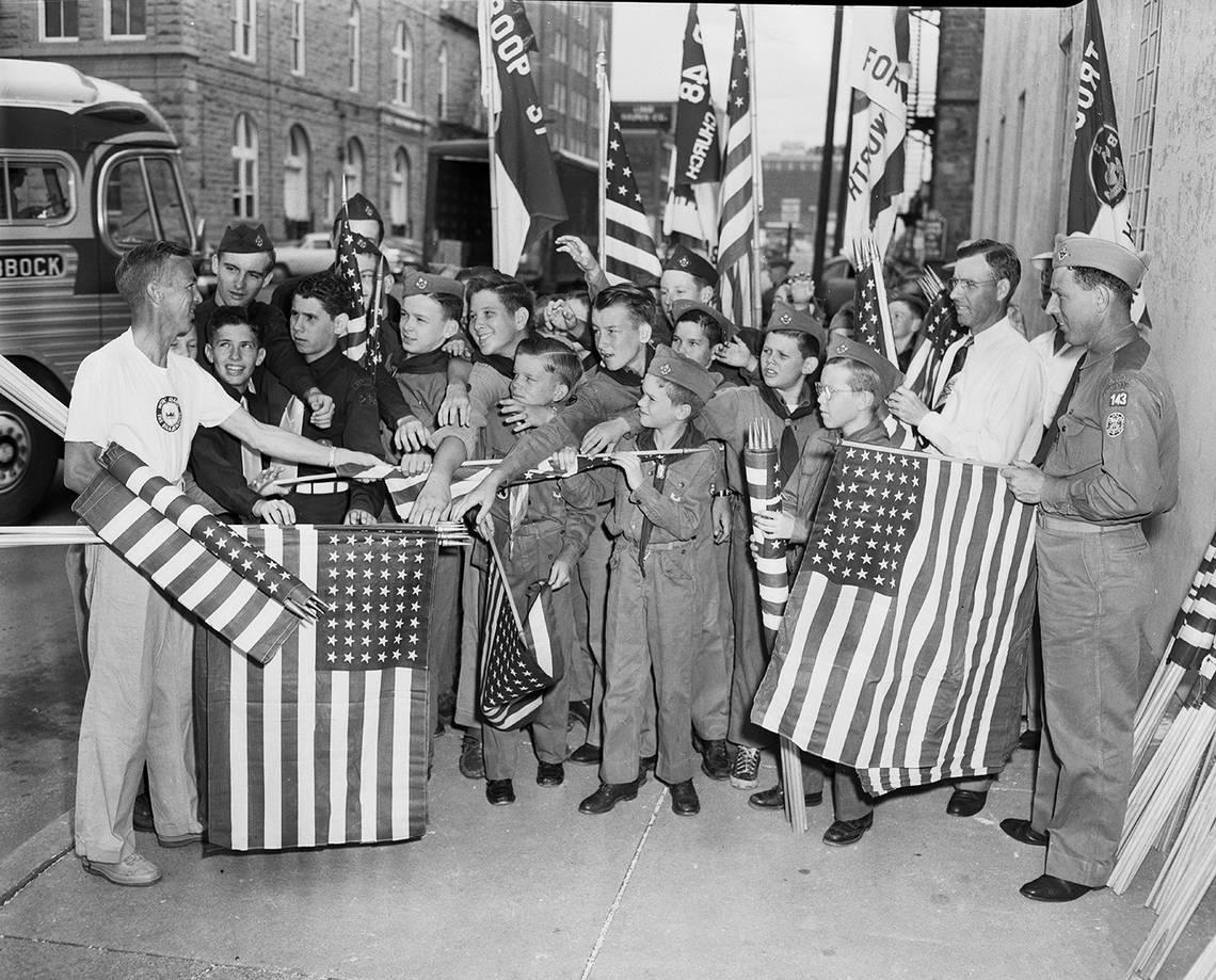 June 16, 1951: The National Guard Armory on E. Lancaster was a distribution point for dozens of U.S. flags with which Boy Scouts and Sea Scouts lined Lancaster for Gen. Douglas MacArthur’s entrance into the city. Handing them out is Art Miller, left, Horned Frog Boy Scout district commissioner, assisted by Scoutmaster Joe Waggoner, in uniform at right, and Buck Rosenthal, assistant scoutmaster, at Waggoner’s right. Fort Worth Star-Telegram archive/UT Arlington Special Collections