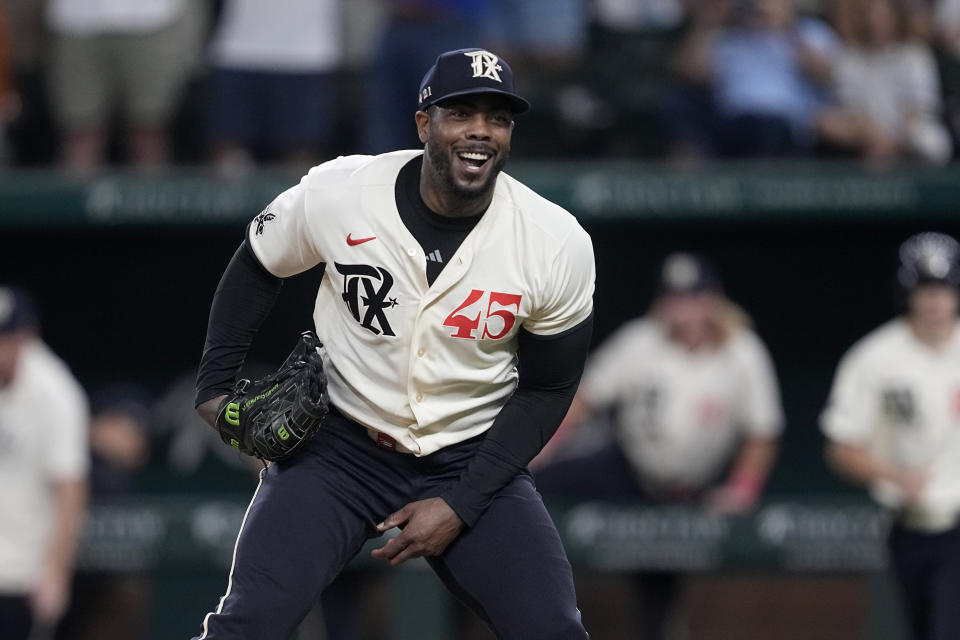 Texas Rangers relief pitcher Aroldis Chapman smiles at the Seattle Mariners dugout after getting Mariners' Luis Torrens to ground out for the last out in the ninth inning of a baseball game, Saturday, Sept. 23, 2023, in Arlington, Texas. (AP Photo/Tony Gutierrez)