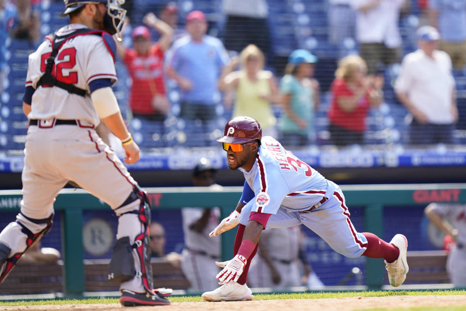 Philadelphia Phillies' Odubel Herrera, right, scores the game-winning run past Atlanta Braves catcher Kevan Smith on a two-run single by Jean Segura during the 10th inning of a baseball game, Thursday, June 10, 2021, in Philadelphia. (AP Photo/Matt Slocum)