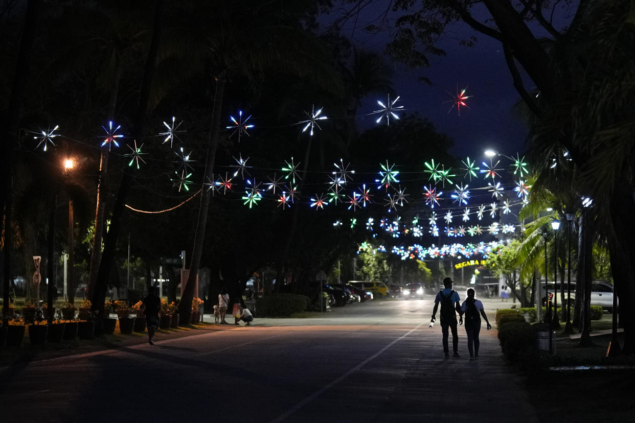 People walk under street decorations inside what used to be America's largest overseas naval base at the Subic Bay Freeport Zone, Zambales province, northwest of Manila, Philippines on Monday Feb. 6, 2023. The U.S. has been rebuilding its military might in the Philippines after more than 30 years and reinforcing an arc of military alliances in Asia in a starkly different post-Cold War era when the perceived new regional threat is an increasingly belligerent China. (AP Photo/Aaron Favila)