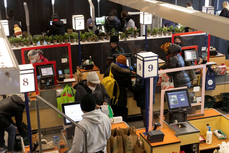 FILE PHOTO: People pay for their purchases at a supermarket in Manhattan, New York City