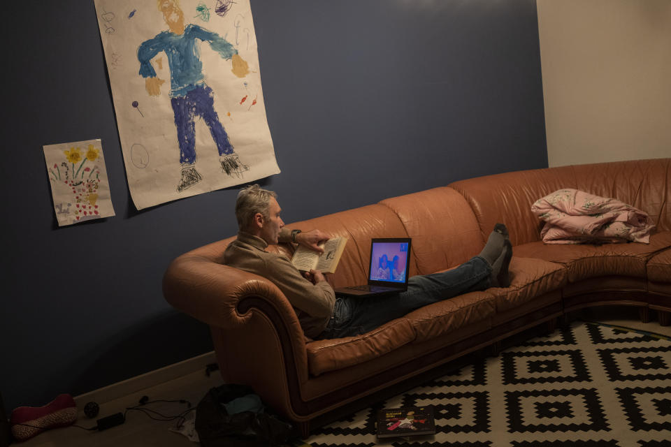 Ukrainian entrepreneur Yevhen Potoplyak, 42, reads a story to his sons Ostab and Denys via videoconference in Lviv, western Ukraine, Thursday, March 17, 2022. Yevhen's two sons and his wife Maria left for Poland on Feb. 26. (AP Photo/Bernat Armangue)