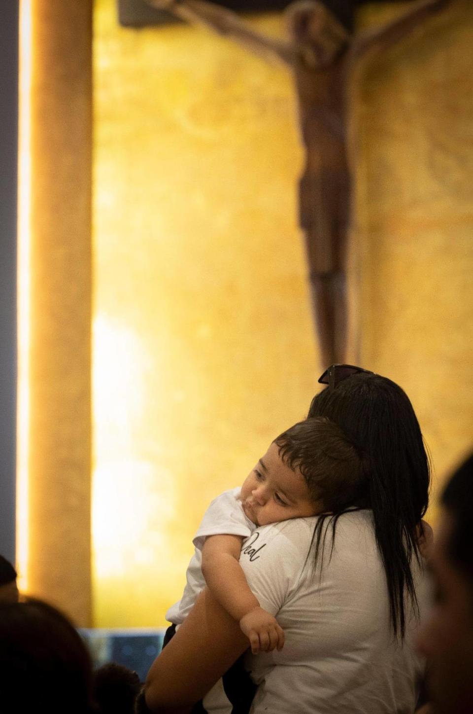 María Chirinos sosteniendo a su hijo Jhonder, de un año, durante la misa antes de su ceremonia de bautismo el domingo 10 de septiembre de 2023 en la iglesia católica Corpus Christi de Miami. Muchos de los niños bautizados eran refugiados inmigrantes acogidos en la iglesia como parte de un esfuerzo de los Hermanos de la Calle, una organización que lucha contra la falta de vivienda. Alie Skowronski/askowronski@miamiherald.com