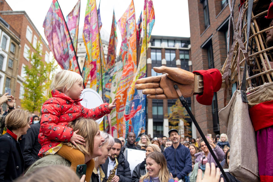 A child reaches out to make contact with Little Amal in London on Oct. 23, 2021.