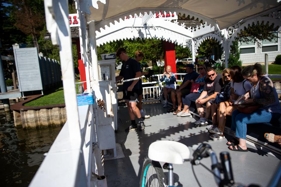 Passengers load onto the Saugatuck Chain Ferry Friday, Aug. 12, 2022, in downtown Saugatuck. The boat pulls passengers across the river by a gearbox and chain that runs the length of the river.