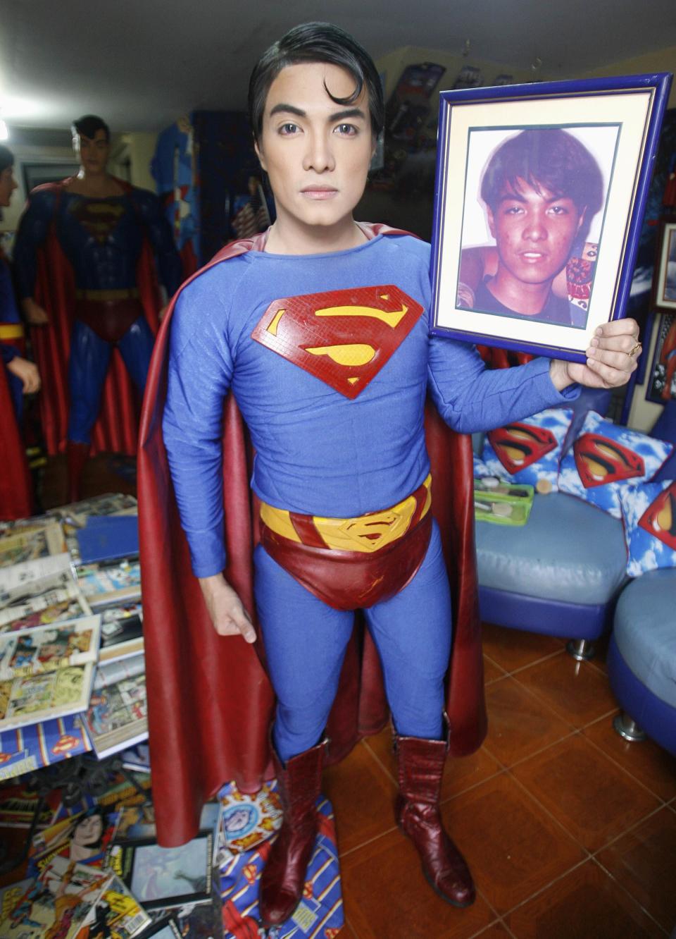 Herbert Chavez holds a photo of himself at 16, taken before his cosmetic transformation to look like his idol Superman, inside his house in Calamba Laguna, south of Manila October 12, 2011. In his idolization of the superhero, Chavez, a self-professed "pageant trainer" who owns two costume stores, has undergone a series of cosmetic surgeries for his nose, cheeks, lips and chin down to his thighs and even his skin color to look more like the "Man of Steel". The final result bears little resemblance to his old self. REUTERS/Cheryl Ravelo (PHILIPPINES - Tags: SOCIETY)