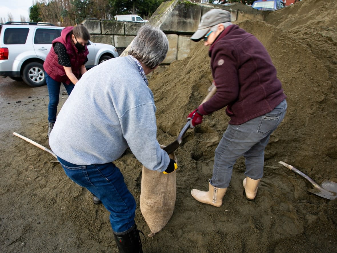 Residents of Victoria assemble sandbags on Monday ahead of another powerful rainstorm expected to hit southwestern B.C. on Tuesday. (Ken Mizokoshi/CBC - image credit)