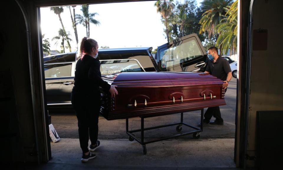 Funeral workers load the casket of a person who died after contracting Covid-19 into a hearse at East County Mortuary in El Cajon, California.