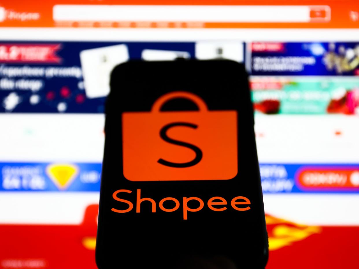 Shopee logo displayed on a phone screen and Shopee website displayed on a laptop screen