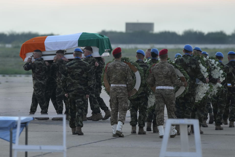 Irish U.N peacekeepers, carry the coffin draped by their country flag of their comrade Pvt. Seán Rooney who was killed during a confrontation with residents near the southern town of Al-Aqbiya on Wednesday night, during his memorial procession at the Lebanese army airbase, at Beirut airport, Sunday, Dec. 18, 2022. (AP Photo/Hussein Malla)