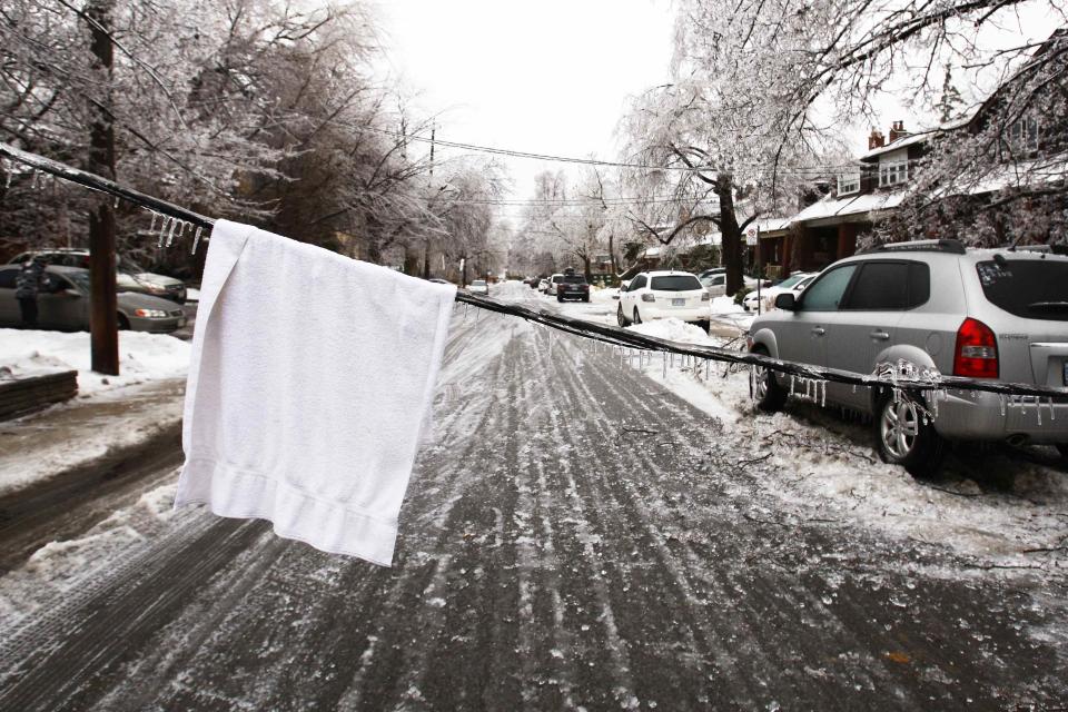 A white towel is placed over a downed powerline to alert passing vehicles after freezing rain in Toronto