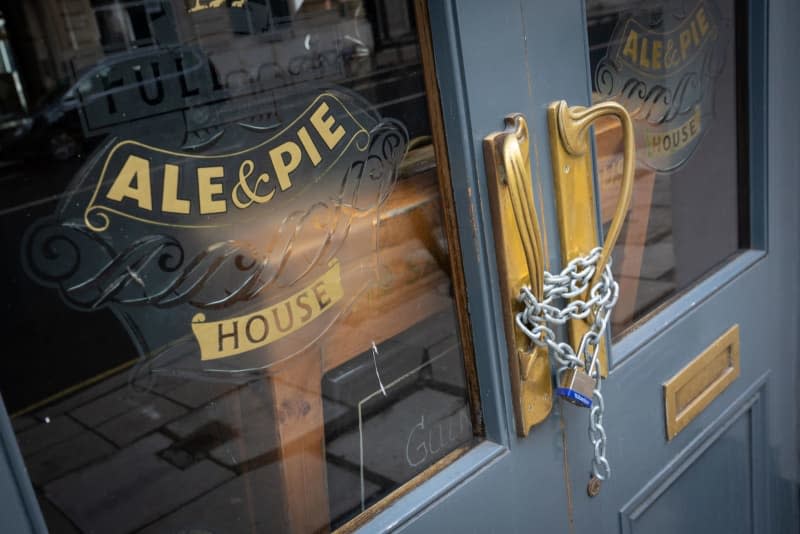 Chains secure the doors of a closed Fuller's pub. According to a study, significantly more pubs in Britain closed down last year. Dominic Lipinski/PA Wire/dpa