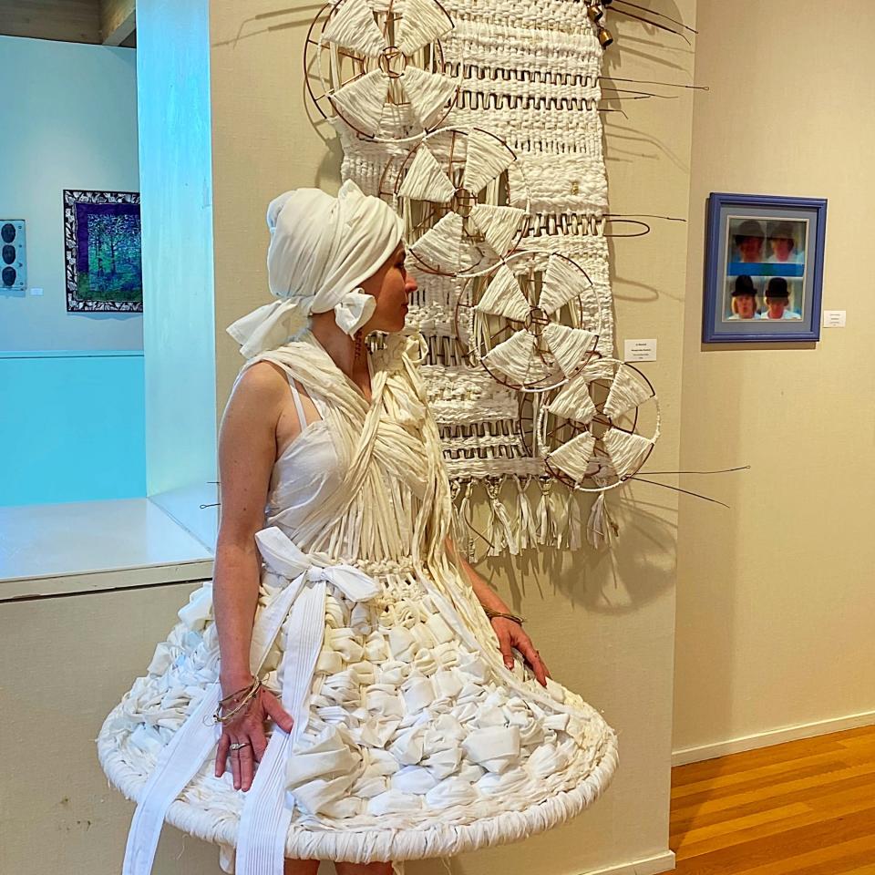 Fiber and mixed media artist Jo Westfall wears a dress that goes with her artwork.