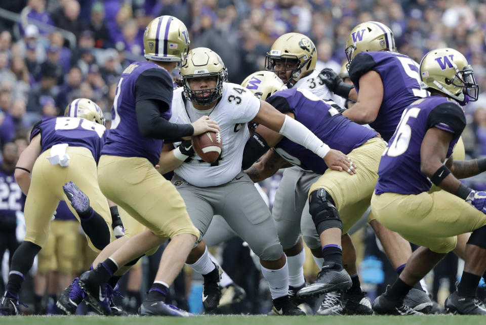 Washington quarterback Jake Browning, left, is pressured by Colorado defensive lineman Mustafa Johnson during the first half of an NCAA college football game, Saturday, Oct. 20, 2018, in Seattle. (AP Photo/Ted S. Warren)