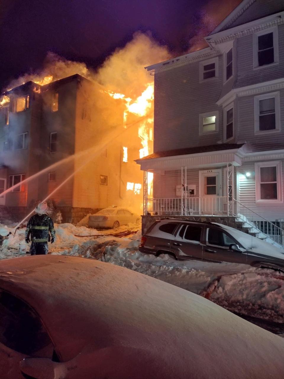 Fall River firefighters battle a four-alarm fire at a multi-family home at 140 Irving St. on Saturday, Jan. 29, 2022.