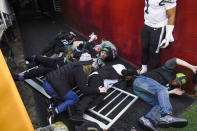 Fans lay on the ground after falling onto Philadelphia Eagles quarterback Jalen Hurts (1) as a railing collapsed following the end of an NFL football game, Sunday, Jan. 2, 2022, in Landover, Md. Philadelphia won 20-16. (AP Photo/Alex Brandon)