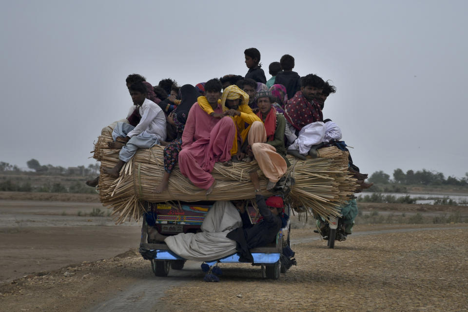 Local residents travel on a vehicle as they flee from a coastal village due to Cyclone Biparjoy approaching, in Golarchi near Badin, Pakistan's southern district in the Sindh province, Wednesday, June 14, 2023. The coastal regions of India and Pakistan were on high alert Wednesday with tens of thousands being evacuated a day before Cyclone Biparjoy was expected to make landfall. (AP Photo/Umair Rajput)