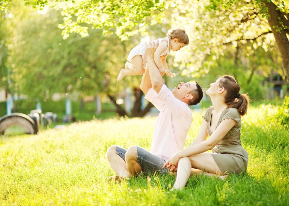 Happy young family sitting in a park.