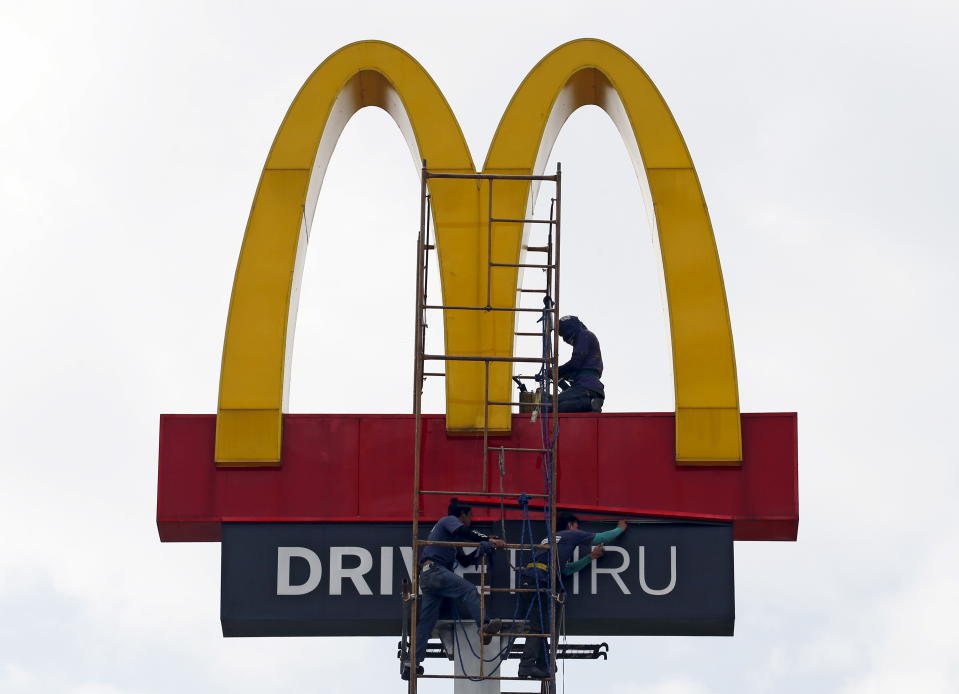 คนงานซ่อมโลโก้บนป้าย McDonald's ใน Paranaque, Metro Manila 6 ตุลาคม 2015 ถ่าย 6 ตุลาคม 2015 REUTERS/Erik De Castro