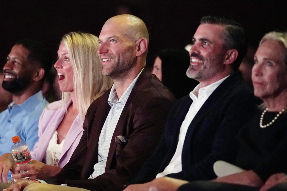 Former Cleveland Browns player Joe Thomas, center, and his wife, Annie Thomas, second from left, laugh during a tribute to the late NFL player Jim Brown Thursday, Aug. 3, 2023, in Canton, Ohio. Thomas is a member of the incoming 2023 class of the NFL Hall of Fame. Second from right is Cleveland Brown head coach Kevin Stefanski. (AP Photo/Sue Ogrocki)