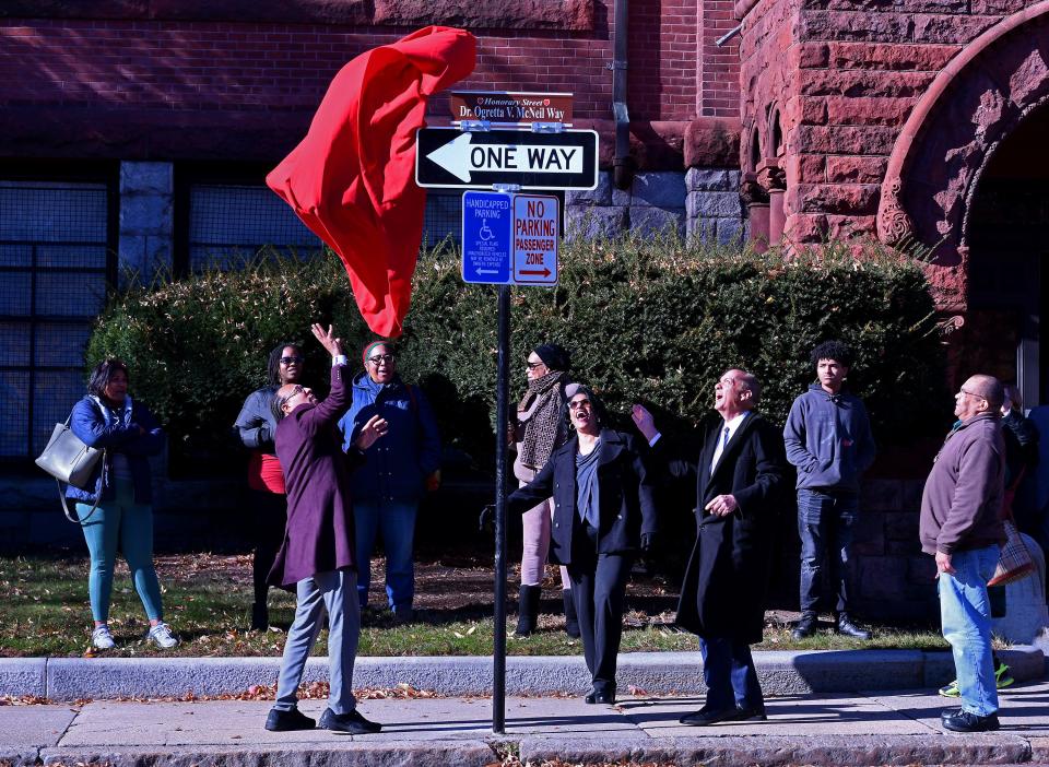 City Councilor Khrystian King, left, and Mayor Joseph Petty discover that the wind really wanted to unveil the honorary street sign to Ogretta V. McNeil before the ceremony Monday.