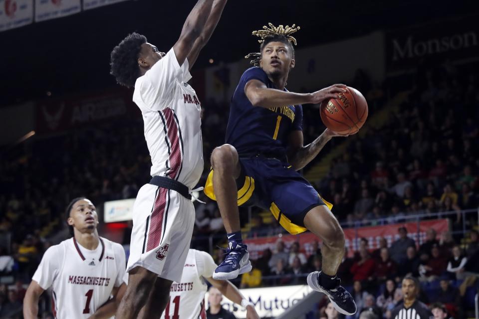 West Virginia's Noah Farrakhan (1) shoots against UMass' Jaylen Curry during the first half of an NCAA college basketball game in the Basketball Hall of Fame Classic, Saturday, Dec. 16, 2023, in Springfield, Mass. (AP Photo/Michael Dwyer)