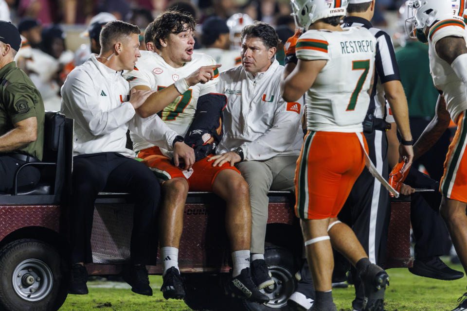 Injured Miami quarterback Emory Williams (17) speaks with his teammates as he is taken off the field late in the fourth quarter of an NCAA college football game against Florida State, Saturday, Nov. 11, 2023, in Tallahassee, Fla. (AP Photo/Colin Hackley)