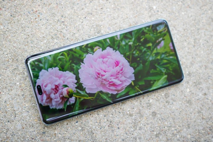 The Honor 200 Pro, with its screen on showing a picture of pink flowers.
