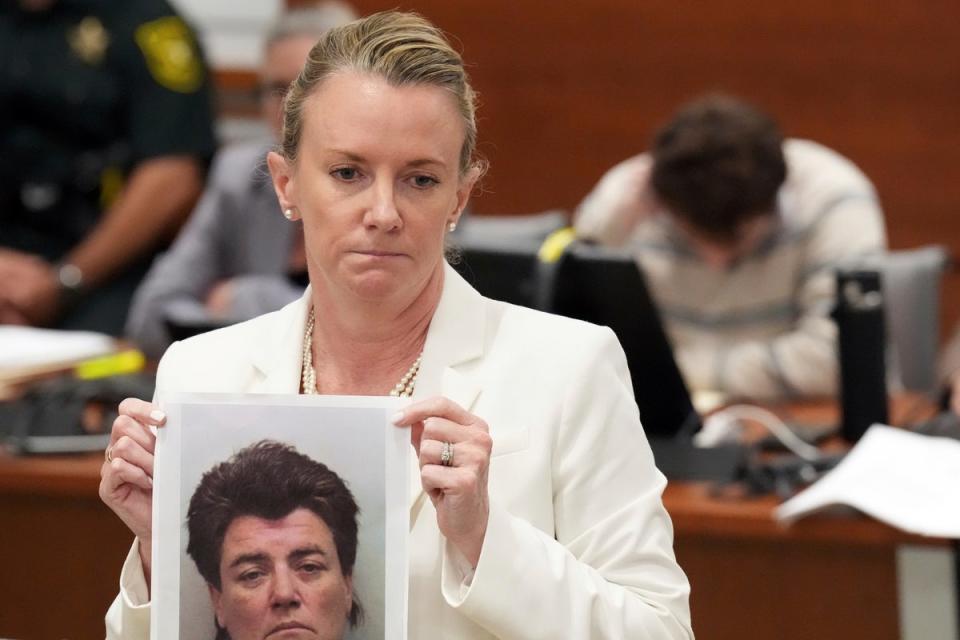 Melisa McNeill holds up a photo of Cruz’s biological mother Brenda Woodard (AP)