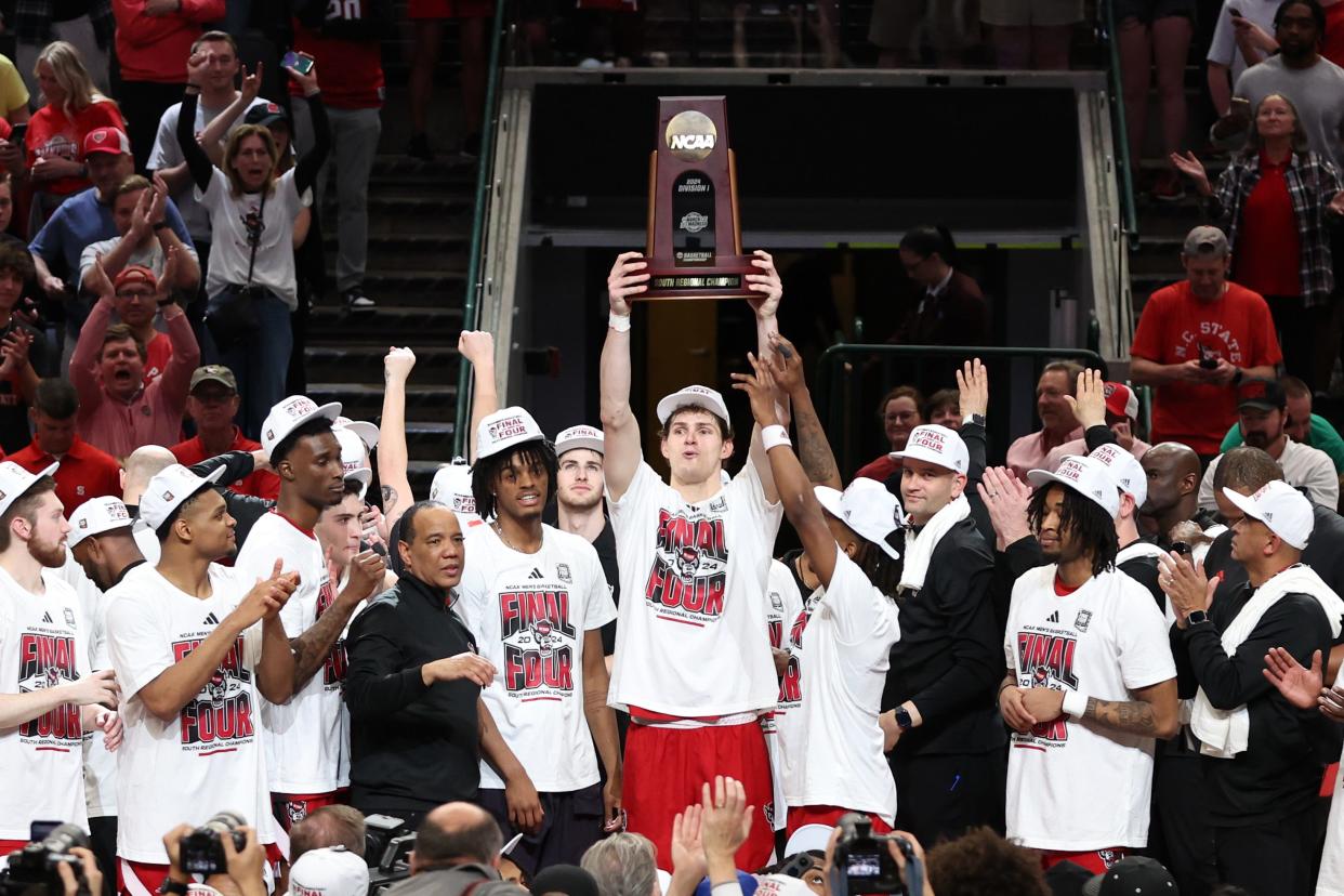 North Carolina State forward Ben Middlebrooks (34) and teammates celebrate with the Sour Regional trophy after defeating Duke to reach the Final Four of the 2024 NCAA men's tournament at American Airline Center.