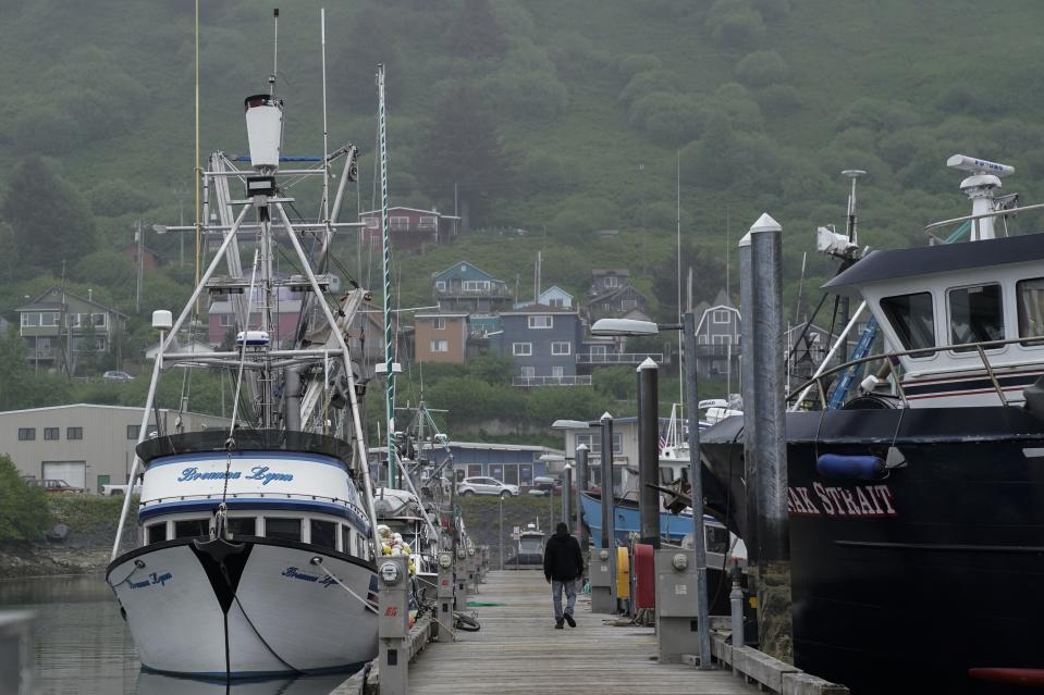 A person walks across the dock at St. Paul Harbor, Thursday, June 22, 2023, in Kodiak, Alaska. (AP Photo/Joshua A. Bickel)