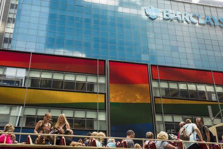 Tourists on a bus move past a Barclays building as the LGBT rainbow flag is displayed on its digital screens in New York, June 26, 2015. REUTERS/Lucas Jackson