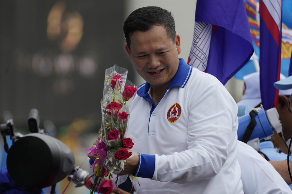 Hun Manet, a son of Cambodia Prime Minister Hun Sen, receives flowers from his supporters as he leads a procession to mark the end of an election campaign of Cambodian People's Party, in Phnom Penh, Cambodia, on July 21, 2023. Cambodian King Norodom Sihamoni on Monday, Aug. 7, formally endorsed army chief Hun Manet to succeed his father and long-ruling Prime Minister Hun Sen as the nation's leader later this month after their party sealed victory in a one-sided election last month. (AP Photo/Heng Sinith)