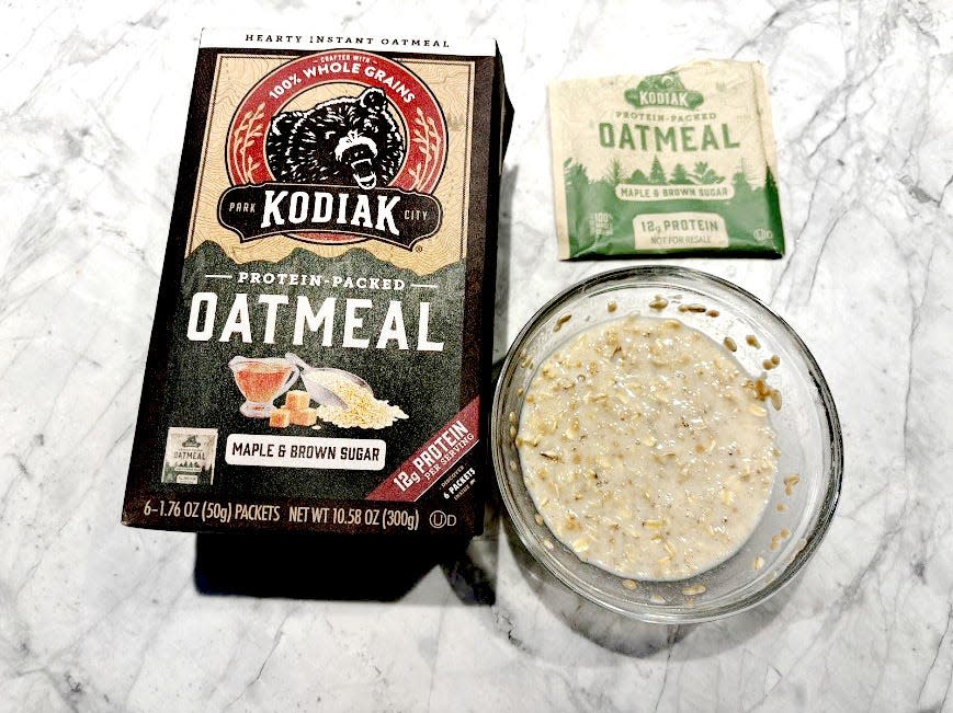 Kodiak protein oatmeal box next to empty packet and bowl of oatmeal 