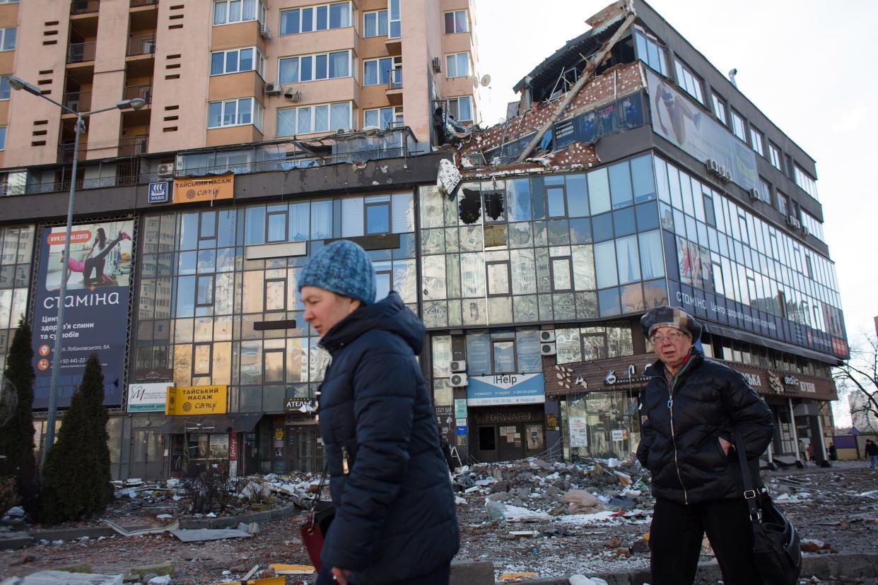 Women pass by the apartment block in 6A Lobanovsky Ave. which was hit with a missile on Feb. 26, 2022, in Kyiv, Ukraine.