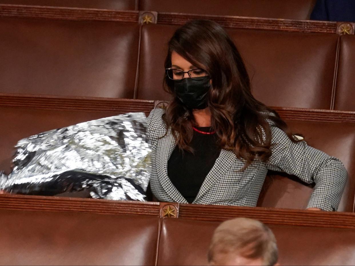 Colorado congresswoman Lauren Boebert unrolls a lightweight  blanket as US president Joe Biden speaks to a joint session of Congress in the House chamber of the US Capitol in Washington, DC (Andrew Harnik/Reuters)