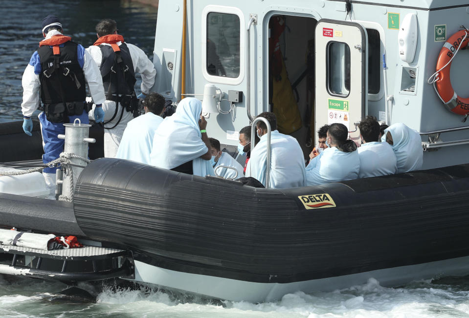 A Border Force vessel brings a group of people thought to be migrants into the port city of Dover, southern England, Sunday Aug. 9, 2020. Many migrants have used small craft during the recent hot calm weather to make the dangerous journey from northern France, to cross the busy shipping lanes of The Channel to reach Britain. Photo credit should read: Yui Mok/PA Wire( /PA via AP)