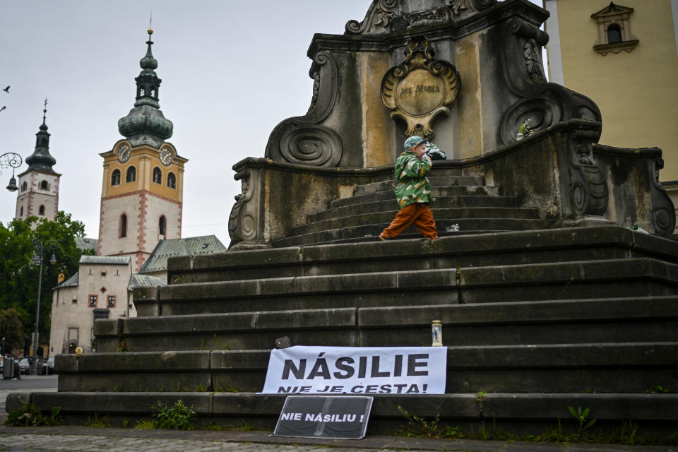 A child walks next to a banner that reads "Violence is Not the Way" and " No Violence" in Banska Bystrica, central Slovakia, Friday, May 17, 2024. When a gunman shot Slovak Prime Minister Robert Fico this week, shock rippled across the Central European country — even though the pro-Russia leader himself warned that the country was so divided that an assassination attempt was possible.(AP Photo/Denes Erdos)