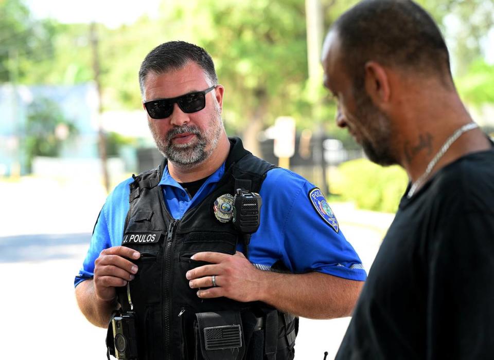 Bradenton police officer Jordan Poulos talks to people without housing on the street behind the Salvation Army.