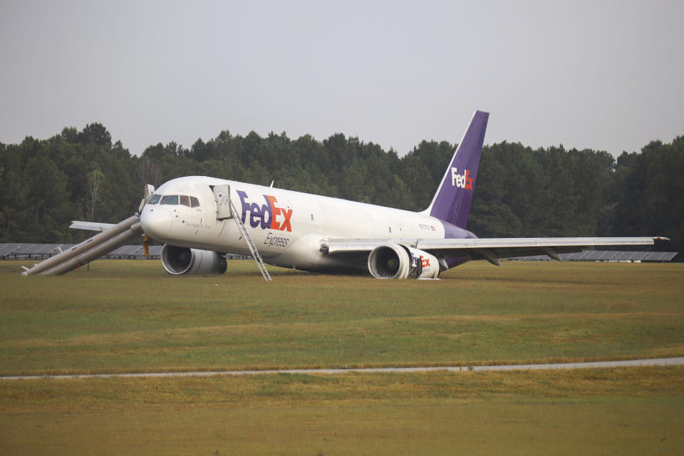 A FedEx 757 sits on a landing strip Thursday, Oct. 5, 2023 at the Chattanooga Metropolitan Airport after crash landing late Wednesday evening. Officials say the FedEx plane skidded off the runway during a crash landing when its landing gear did not descend, but no one was injured. (Olivia Ross /Chattanooga Times Free Press via AP)