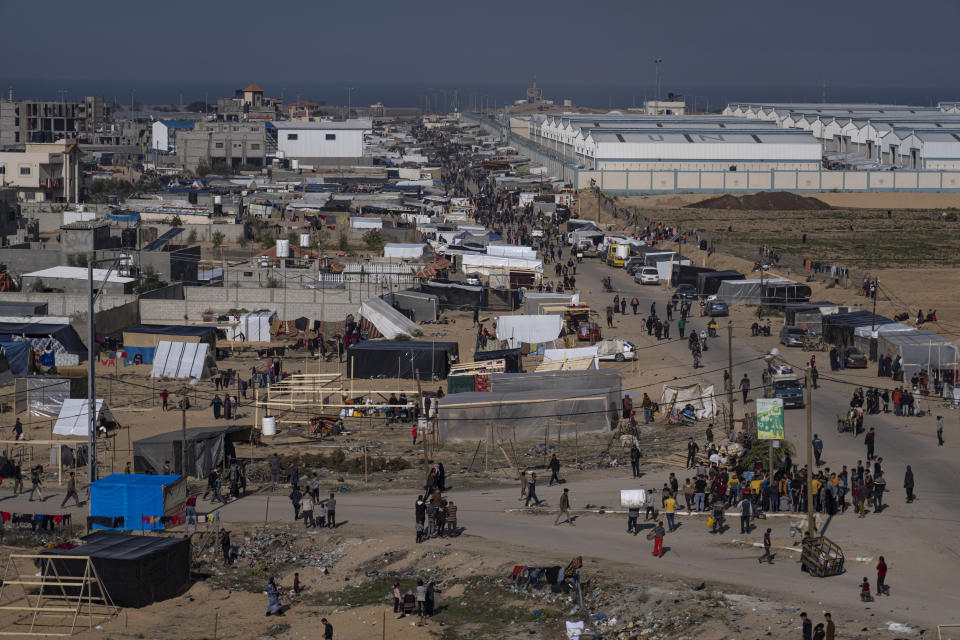 Palestinians displaced by the Israeli bombardment of the Gaza Strip gather at a tent camp, in Rafah, southern Gaza strip, Monday, Dec. 4, 2023. Hundreds of thousands of Palestinians have fled their homes as Israel moves ahead with a ground offensive against the ruling Hamas militant group. (AP Photo/Fatima Shbair)