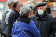 People wearing face masks walk down a street in Saint Jean de Luz, southwestern France, Wednesday, Oct.28, 2020. France is bracing for a potential new lockdown as the president prepares a televised address Wednesday aimed at stopping a fast-rising tide of virus patients filling French hospitals and a growing daily death toll. French markets opened lower on expectations that President Emmanuel Macron will announce some kind of lockdown Wednesday.(AP Photo/Bob Edme)