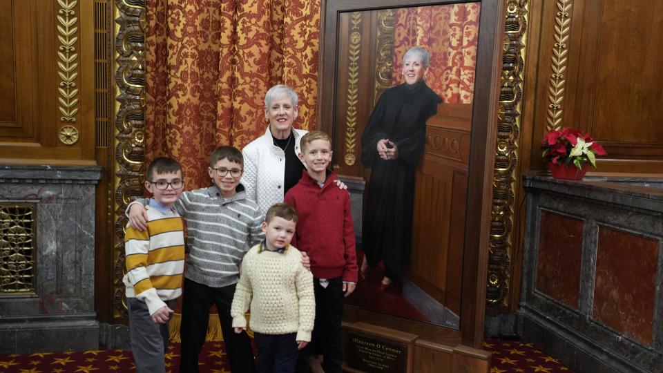 Dec 9, 2022; Chief Justice Maureen O'Connor poses with her grandchildren at her portrait dedication ceremony at the Thomas J. Moyer Ohio Judicial Center. Mandatory Credit: Doral Chenoweth/The Columbus Dispatch