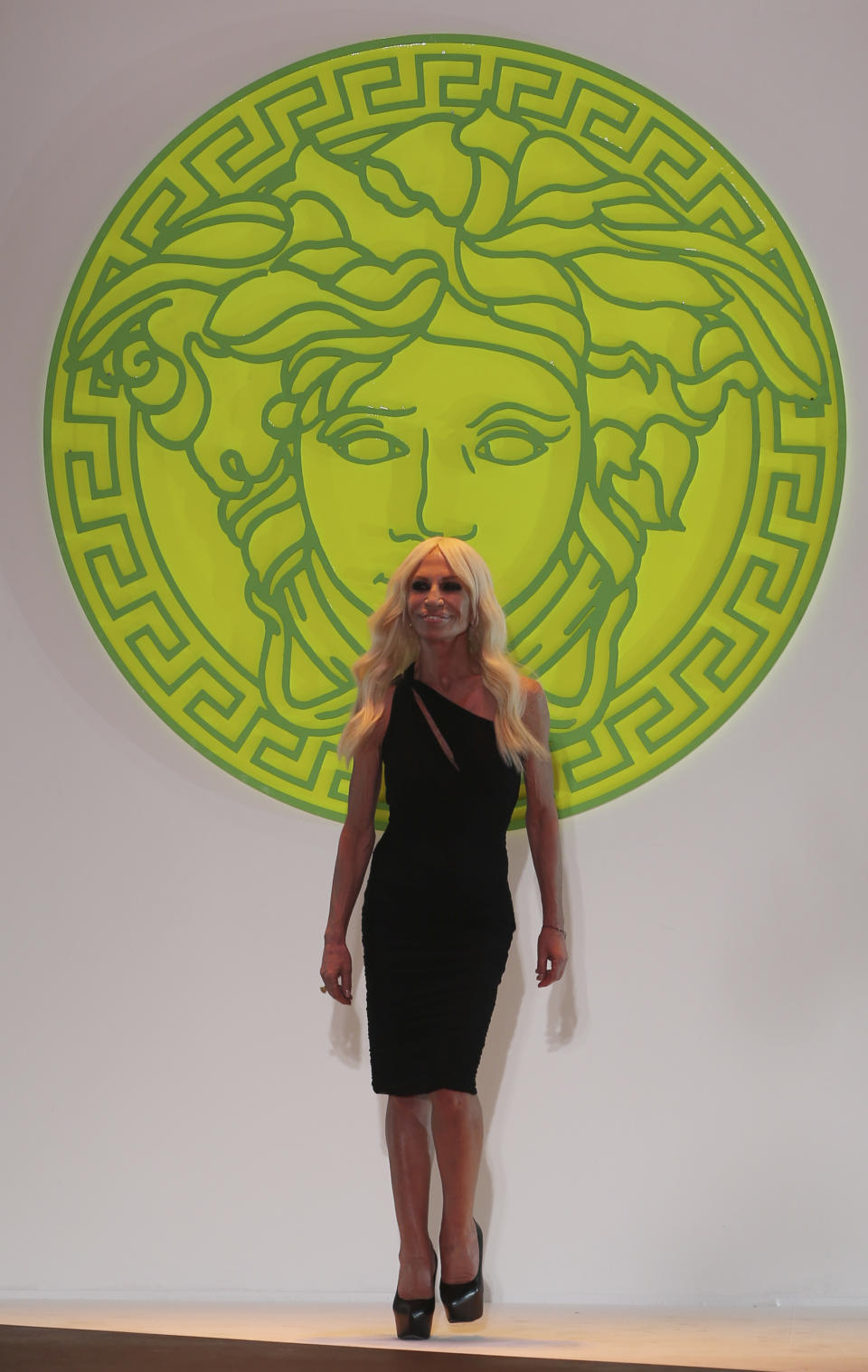 Italian fashion designer Donatella Versace walks on the catwalk at the end of the Versace men's Spring-Summer 2014 fashion show, part of the Milan Fashion Week, unveiled in Milan, Italy, Saturday, June 22, 2013. (AP Photo/Luca Bruno)