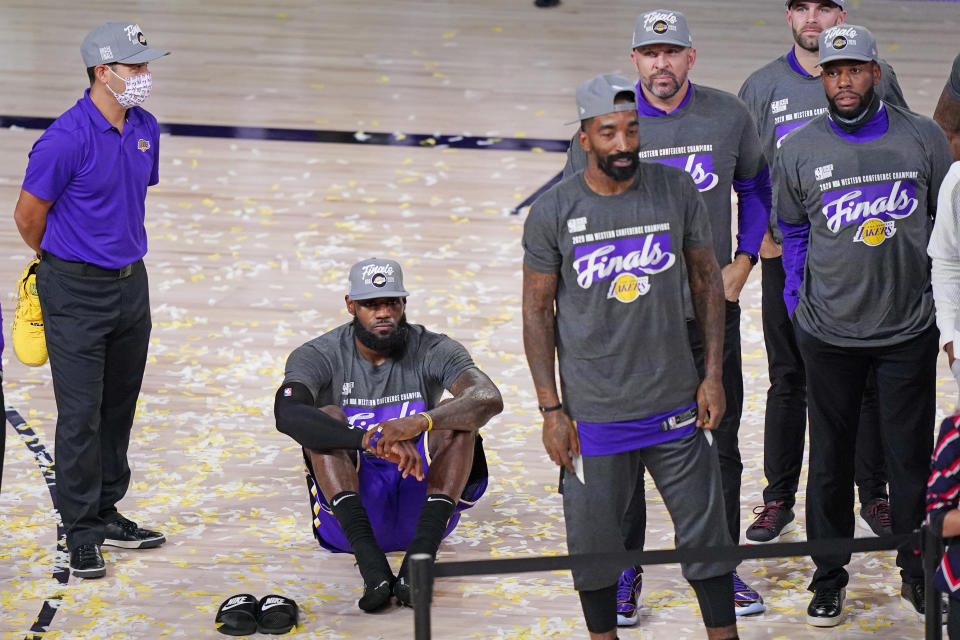 Los Angeles Lakers' LeBron James sits on the floor as he waits for the trophy ceremony to start after the Lakers beat the Denver Nuggets in an NBA conference final playoff basketball game Saturday, Sept. 26, 2020, in Lake Buena Vista, Fla. The Lakers won 117-107 to win the series 4-1. (AP Photo/Mark J. Terrill)